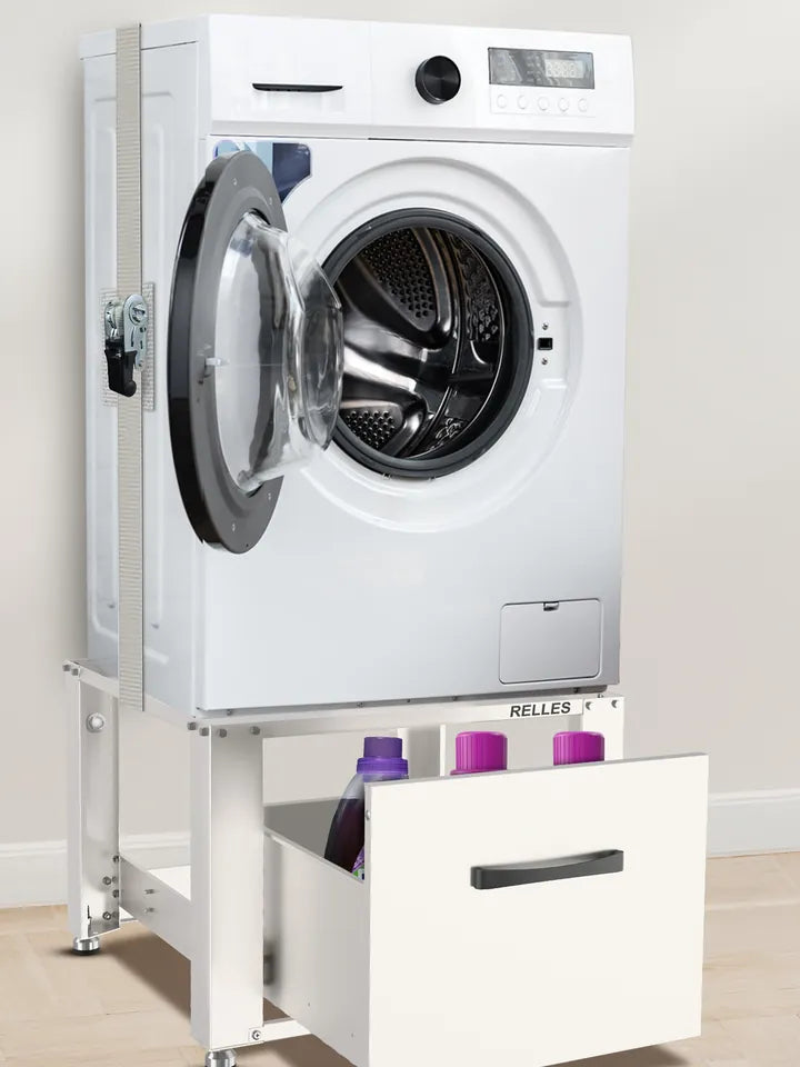 Washing machine on a white RELLES base frame with drawer, secured to the frame with a tension strap